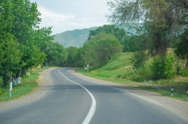 Dağların eteklerine doğru manzaralı bir yolculuk yap. Yol boyunca nefes kesici manzaralar keşfedin. Dağların eteklerinde rahatla ve rahatla..