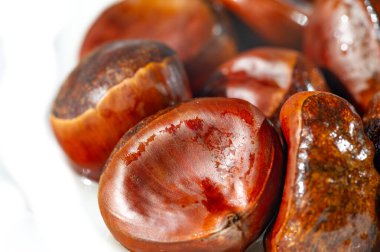 Beyaz arka planda kestanelerin güzel bir görüntüsü. Sonbaharın özünü en saf haliyle yakalar. Mevsimin güzelliklerini yakalamak ve sakin bir atmosfer yaratmak için ideal..