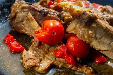 Lezzetli bir zıtlık için olgun kırmızı domateslerle servis edilen leziz kızarmış domuz kaburgaları ağız sulandırıcı ve tatlı tatların karışımı.