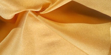 Sarı renkli ipek kumaş. Renkli ipek kumaşın dokusu arka plan olarak kullanılabilir