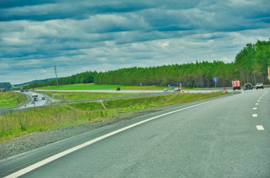 Otoyol boyunca doğada manzaralı bir yolculuğun tadını çıkar. Yol boyunca uzanan görkemli ağaçların güzelliğine dalın. Otoyolda giderken manzaranın tadını çıkarın..