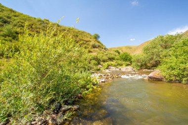 Kayalık kanyonda akan nehrin sükunetini hisset. Kendinizi doğanın güzelliklerine daldırın. Etrafındaki dağların huzurunu hisset.