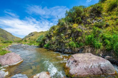 Görkemli bir kanyonda akan bir nehrin sükunetini hissedin. Doğayla bağlantı kurun ve çarpıcı dağ manzarasına hayran olun. Doğal manzaranın güzelliğine ve dinginliğine dalın..