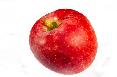 Kırmızı elma sağlık ve canlılığı sembolize eder. Vitamin ve mineral açısından zengin. Sulu ve olgun, doyurucu bir atıştırmalık için uygun. Beyaz arka plan elmanın tazeliğini vurgular..