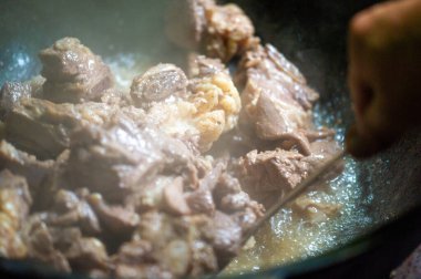 Kazanda lezzetli bir kuzu güveci hazırlayın. Lezzet katmak için, eti tereyağı ile fırçalayın ve kısaltın..