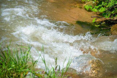 Bir dağ deresinde doğanın dokunulmamış güzelliğini deneyimleyin. Su ve taşların büyüleyici dansını keşfedin. Bu huzurlu ortamda ışık oyununun ve karmaşık detayların tadını çıkarın..