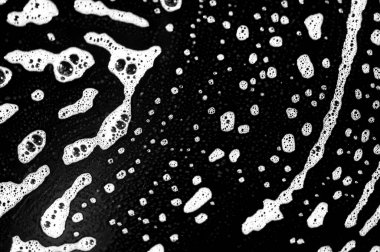 Sabun köpükleri yüzeyde kabarcıklı bir doku oluşturur. Deterjan bulaşıklardaki lekeleri temizleyip çıkarmaya yardımcı olur. Beyaz sabun köpüğüyle siyah tabağın kontrastı görsel ilgi uyandırıyor..