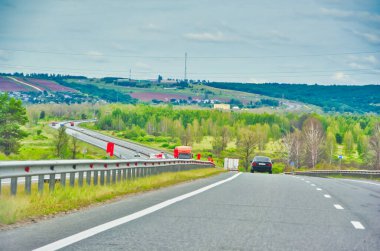 Doğada manzaralı bir yolculuğun tadını çıkar. Otoyol boyunca uzanan görkemli ağaçların güzelliğinin tadını çıkar. Rahat bir araba yolculuğunun huzur ve sükunetini yaşayın..