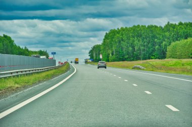Otoyol boyunca doğada manzaralı bir yolculuğun tadını çıkar. Yol boyunca uzanan görkemli ağaçların güzelliğine dalın. Otoyolda giderken manzaranın tadını çıkarın..