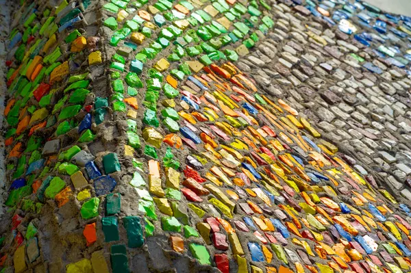 Renk ve şekillerin canlı bir kombinasyonunun tadını çıkar. Şehrin kalbinde etkileyici bir mozaik fayans duvarı duruyor. Sokak sanatı, izleyicileri yaratıcılığın kaleydoskopuna dalmaya davet ediyor..