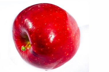 Beyaz arka planda taze ve sulu kırmızı elma. Vitamin ve besin bakımından zengin. Sağlıklı bir atıştırmalık ya da yemeğe ilave olarak ideal..