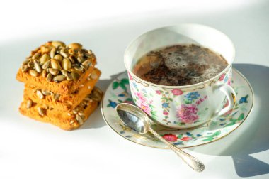 Çeşitli lezzetler ve eşsiz eşyalar sunuyor. Çin porseleni ve siyah çay konusunda uzman. Geniş bir kurabiye ve tahıl gevreği seçeneği mevcuttur.