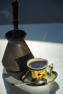 Geleneksel Türk kahvesinin tadını çıkar Narin bir Çin porselen bardağından iç. Kendine lezzetli bir espresso ve şeker karışımı al..