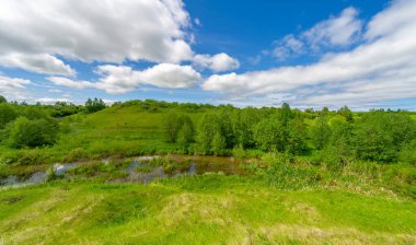 Bahar, tarlalar, vadiler, tepeler, kırsal alanlar. Dik yamaçlı, derin ve dar bir vadi. Doğal olarak yükseltilmiş bir arazi, bir dağ kadar yüksek ya da sarp değil..