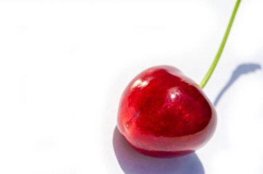 Beyaz arka planda taze kirazlar parlak ve iştah açıcı bir görüntü yaratır. C vitamini ve antioksidan açısından zengin. Sağlıklı bir atıştırmalık için ideal. Sulu ve olgun kirazlar - lezzetli bir vejetaryen seçeneği