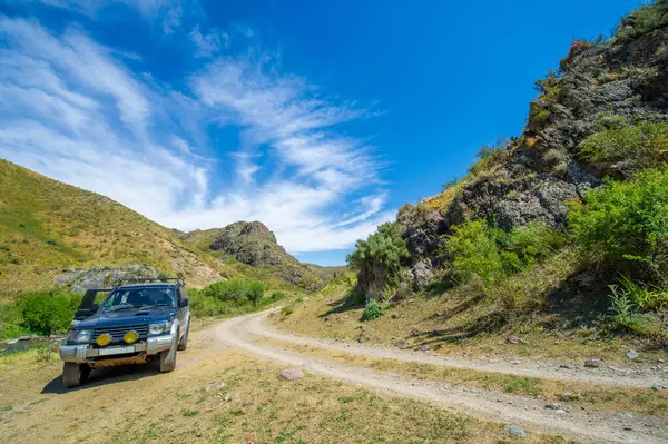 Dağ toprak yolunda off-road macerası seni bekliyor. Engebeli araziyi keşfedin ve çarpıcı manzaranın tadını çıkarın. Heyecan verici off-road maceralarına hazır olun..