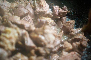 Geleneksel yemek pişirme yöntemleri: Kazan ve yağlı kuzu eti, bol yağlı ve leziz bir yemek.