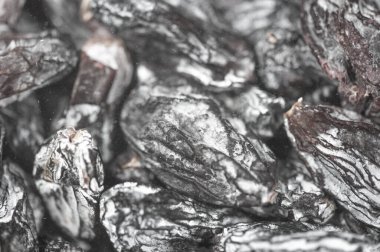 Siyah kuru üzümlerin doğal tatlılığının tadını çıkarın. Bu yakın plan görüntüde zengin dokusunu ve lezzet potansiyelini gösteriyor. Pişirme İyiliği