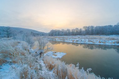 Gün doğumunda bir kış harikalar diyarının güzelliğini tecrübe et. Bak güneş donmuş nehri altın ışıkla nasıl aydınlatıyor. Kendinizi Donmuş Şafak 'ın tuhaf atmosferine daldırın.