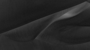 Bulanık siyah ipek kumaş. Gece gökyüzündeki bir yıldız gibi parlak ve parlak, tafta gibi bir vücudu var ama ince bir parıltı yaratan pürüzsüz bir yüzeyi var..