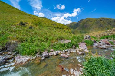 Görkemli nehir kayalık kanyonda zarafetle akıyor. Doğanın güzelliği dağların tam kalbinde ortaya çıkar. Akan suyun ve engebeli arazinin huzurlu sakinliğini hisset..