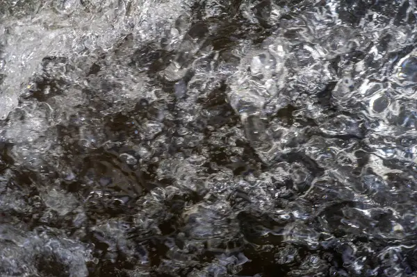 Bulanık odak. Bir dağ deresinin huzurlu güzelliğinin tadını çıkar. Zarif bir şekilde akan berrak suyun nefes kesici görüntüleri. Kendini doğanın rahatlatıcı seslerine bırak..