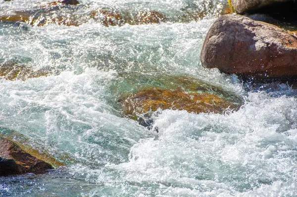 Akan suyun güzelliğini ve doğanın huzurlu manzaralarını yakalayın. Doğadaki ahenk ve sükunete odaklan. Dağınık taşların estetik çekiciliğini vurgula