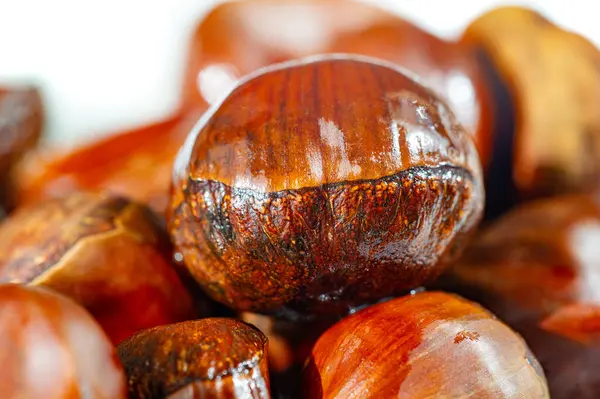 Kestaneler el değmemiş beyaz bir tabakta zarif bir şekilde sunulur, sıcak ve samimi bir düşüş hissi yaratır. Sonbahar Keyifleri