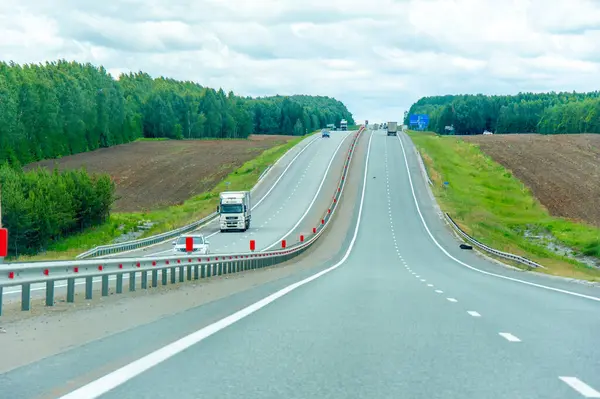 Doğada manzaralı bir yolculuğun tadını çıkar. Otoyoldaki uzun ağaçların güzelliğinin tadını çıkar. Yol boyunca giderken manzaraya hayranlık duy.