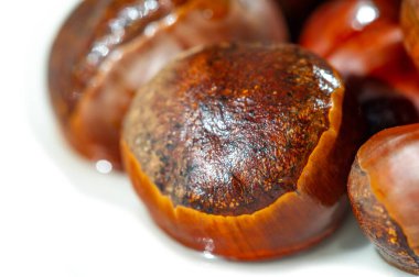 Beyaz arka planda kestanelerin çarpıcı görüntüsü sonbahar temalı pazarlama kampanyalarında kullanmak için ideal mevsimin güzelliğini yakalamak için sonbaharın en saf halini yakalar.