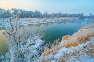 Garip bir kış harikalar diyarının güzelliğini tecrübe et. Donmuş nehrin üzerinden altın güneşin doğuşunu izle. Kış harikalar diyarının büyüsünü tecrübe et. Buz gibi şafak.