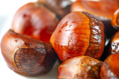 Beyaz arka planda kestanelerin güzel bir görüntüsü. Sonbaharın özünü en saf haliyle yakalar. Mevsimin güzelliklerini yakalamak ve sakin bir atmosfer yaratmak için ideal..