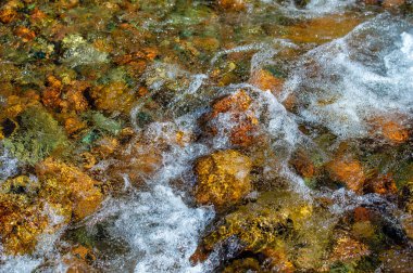 Akan suyun güzelliğini ve huzurunu yakalayın. Doğanın doğal ahengini göster. Düz ve dağınık taşların zarafetini koruyun. Harika fotoğraflar çek.