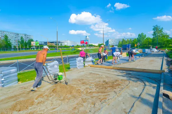 10 08 2014 Rusya Chelny Builders kaldırım için beton döşedi. Beton karıştırıcılar ve güç malaları gibi aletlerin kullanımı. Uygun kurulumu sağlamak için yüzey ölçülüyor ve düzleştiriliyor.