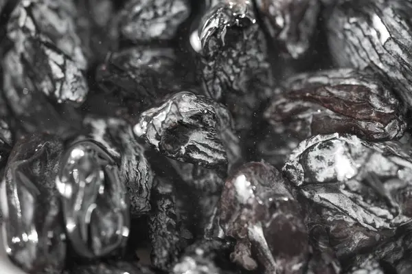 Siyah üzümlerin doğal tatlılığını hisset. Pişirme ve atıştırma için zengin doku ve lezzet seçenekleri. Yakından bakınca siyah kuru üzümlerin tadını ortaya çıkarıyor..