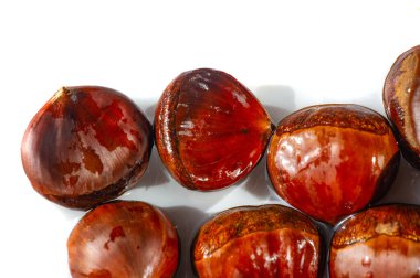 Beyaz arka planda kestane renginde narin kestaneler. İyiliğin sembolü olarak yaratıcı bir şekilde şekillendirilmiş. Kıtır beyaz arka plana sezonluk cazibe yayıyor. Doğa Sanatı