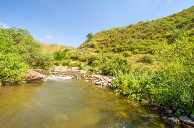 Doğanın dingin güzelliğinin tadını çıkar. Nehrin kayalık kanyonda nasıl zarifçe aktığına bakın. Kendini dağların kalbine daldır..