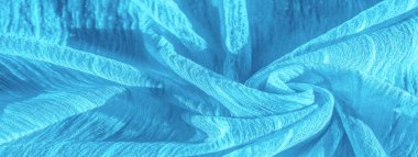 İpek kumaş. Mavi buruşuk kumaş dokusu. Mavi buruşuk, dalgalı yüzey dokusu. Yakın çekim, yumuşak odaklanma. arkaplan, kalıp