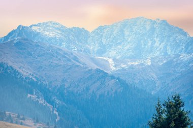 Tien Shan dağlarında sonbahar nefes kesici bir manzaradır. Parlak yeşillikler ve yeşil çam ağaçları bu çarpıcı manzaraya muhteşem bir zemin hazırlar.