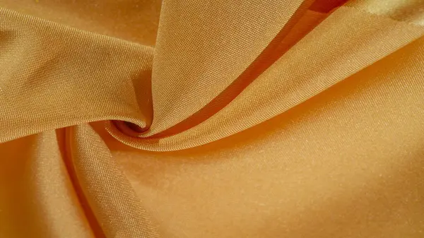 Sarı renkli ipek kumaş. Renkli ipek kumaşın dokusu arka plan olarak kullanılabilir
