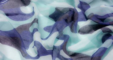Görüntü şeffaf bir kumaş gibi görünüyor yumuşak renklerde kamuflaj deseni, çoğunlukla mavi, yeşil ve gri tonlarında, pürüzsüz ve akışkan bir doku yaratıyor..