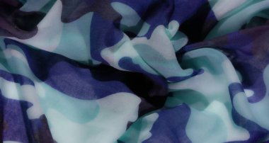 Soyut kamuflaj kumaş deseni, açık mavi, turkuaz ve deniz tonlarında soyut kamuflaj esinlenilmiş yumuşak, akışkan bir kumaşa sahiptir, şeffaf ve dokulu bir görünüm verir..