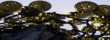 Altın boncuk ve sikke bulanıklığı koyu kumaş üzerine kurulmuş, her parçadan yansıyan ışıkla birlikte. Düzenleme lüks ortamlar için uygun lüks ve lüks bir görünüm yaratıyor.