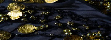 Altın sikkelerle süslenmiş boncuklu kumaş, koyu, zengin bir doku sunuyor lüks bir his, karmaşık detaylar, ve parıldayan metalik gölgeler.