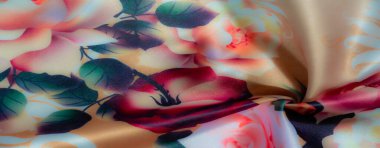 Bulanık, yumuşak turuncu, pembe ve yeşil yapraklarla sarmalanmış krem desenli güzel desenli kumaş. Pürüzsüz, katlanmış malzeme zarafet ve sıcaklık yayar.,