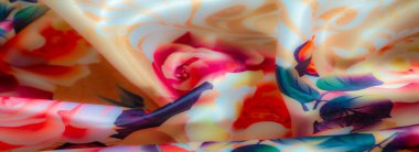 Pembe ve şeftali tonlarında, yeşil ve mor tonlarında yaprakları olan büyük açan güller sergiliyor. Sanatsal desen canlı renklerle yumuşak renkleri birleştirir.