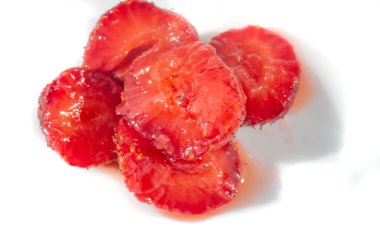 Sulu taze çileklerin yakın plan görüntüsü, biraz dilimlenmiş, doğal böğürtlen suyu dökülmüş. Meyvenin zengin, canlı kırmızı renkleri ve kesik kenarların dokusu bu resmi yemek fotoğrafçılığı için ideal hale getiriyor.