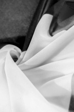 Siyah ve beyaz tonlarda zarif ipek bir dokusu olan lüks bir kumaş. Buruşuk dokusu tasarıma derinlik ve hacim katıyor..