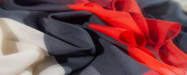 Canlı kumaş koyu kırmızı, klasik siyah ve kıtır beyaz renkte. Benzersiz katlama tekniği görsel ilgi için derinlik ve doku yaratır. Tekstil Sanatı