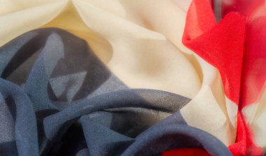 Güzelce katlanmış kumaşlarla kırmızı, siyah ve beyazın zengin renklerini keşfedin. Derinlik ve doku yaratmak görsel cazibeyi arttırır. Tekstil sanatı güzelliğin ince detaylarda yattığını vurgular. 